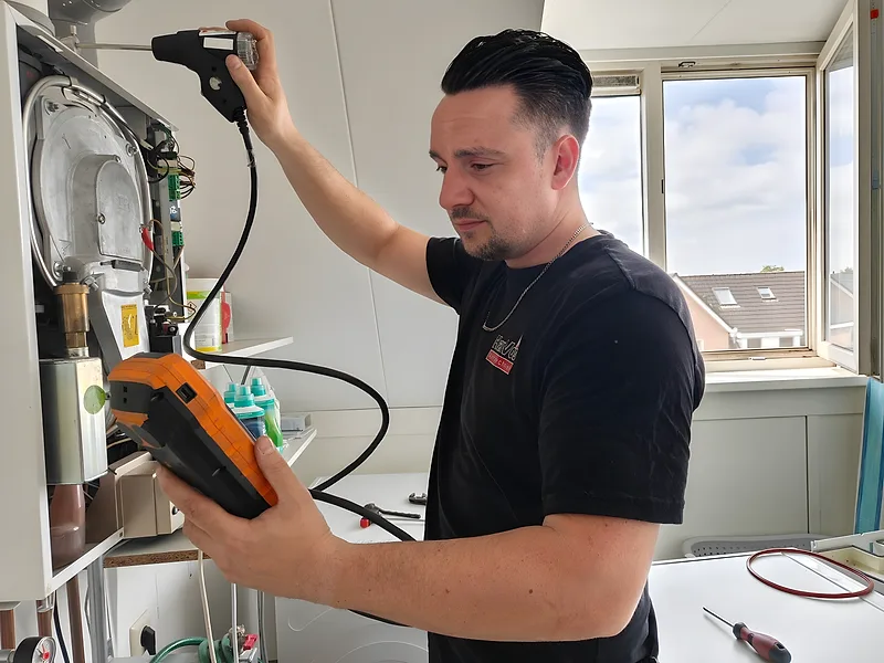 Hanvos-monteur voert onderhoud uit op CV-ketel met rookgasanalyzer