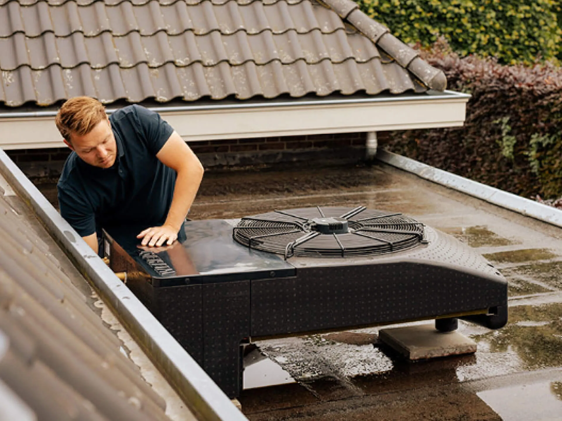 Monteur werkt aan warmtepomp buitenunit op dak
