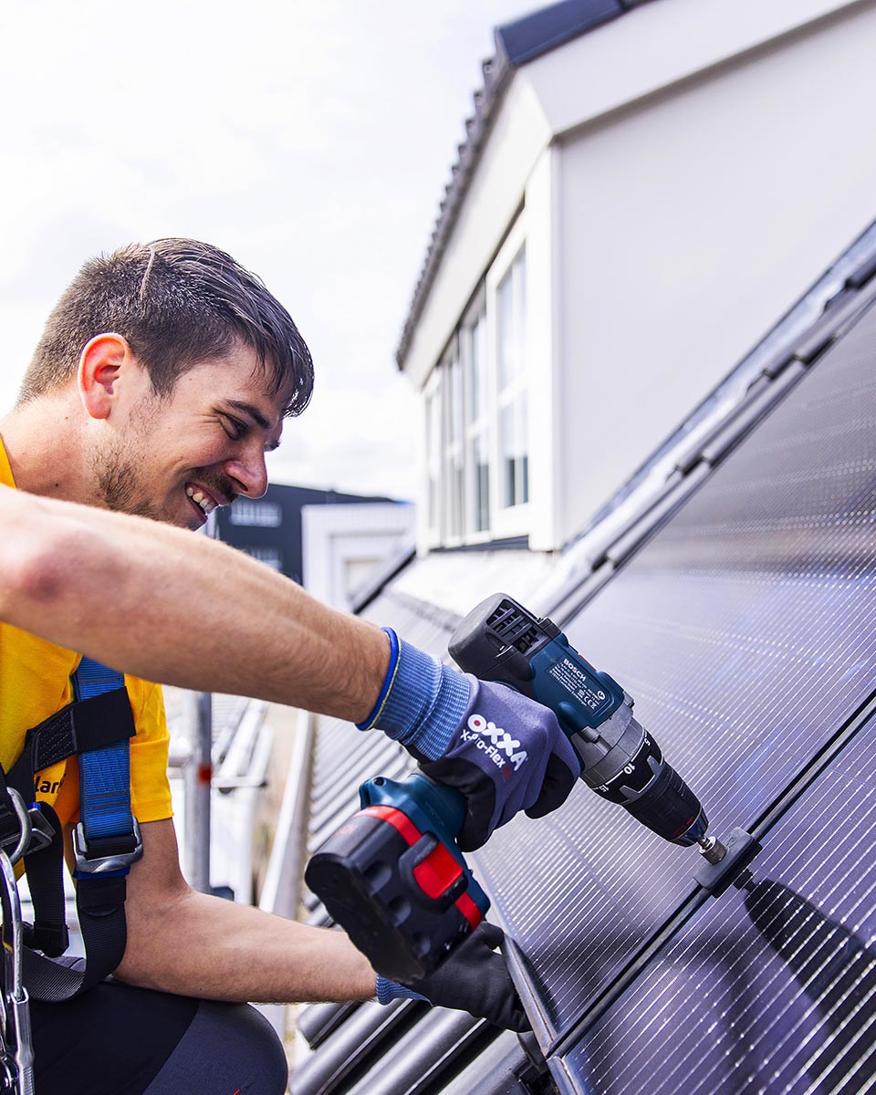 Installateur plaatst zonnepanelen op dak