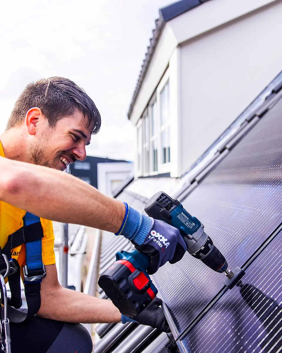 Installateur plaatst zonnepanelen op dak